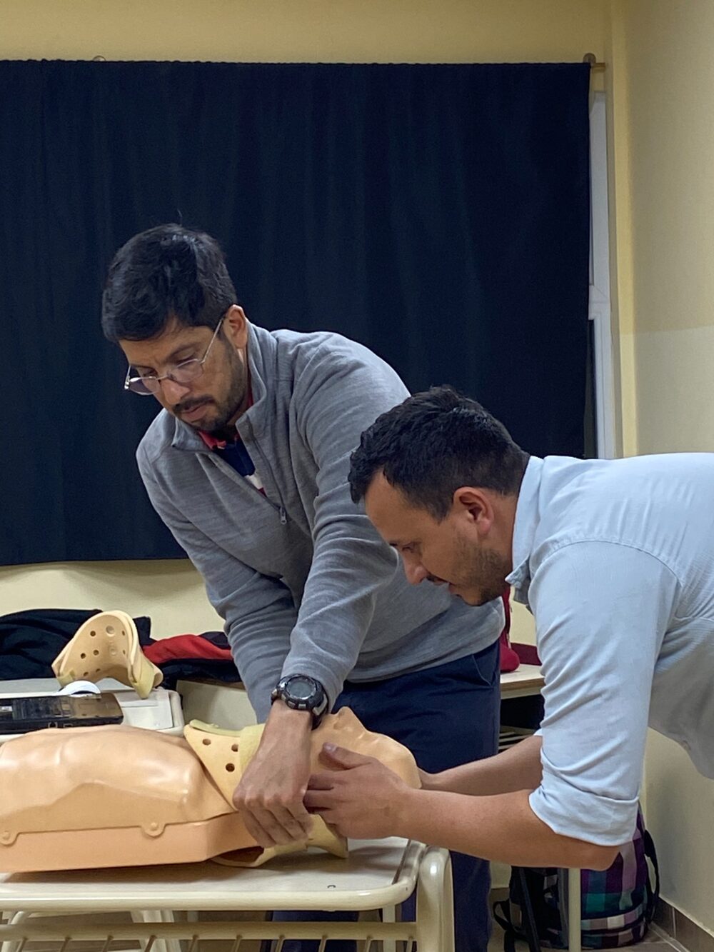 Práctica de inmovilización cervical entre dos instructores